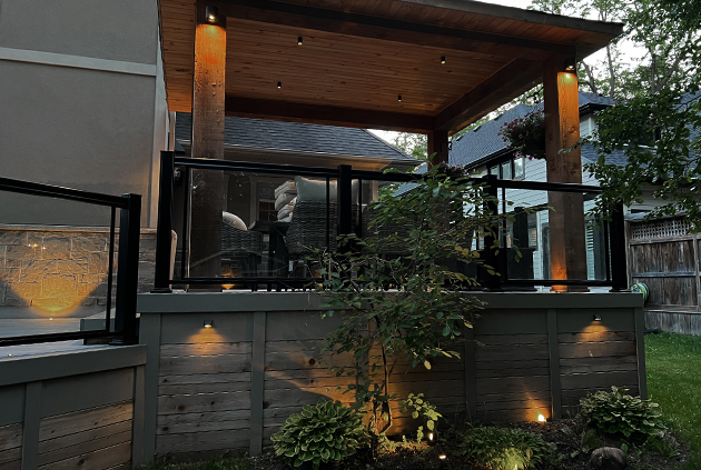 Deck lighting accessories underneath custom deck pavilion with aluminum glass railings.